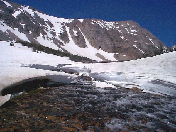 A snowfield erroded by the rushing water.